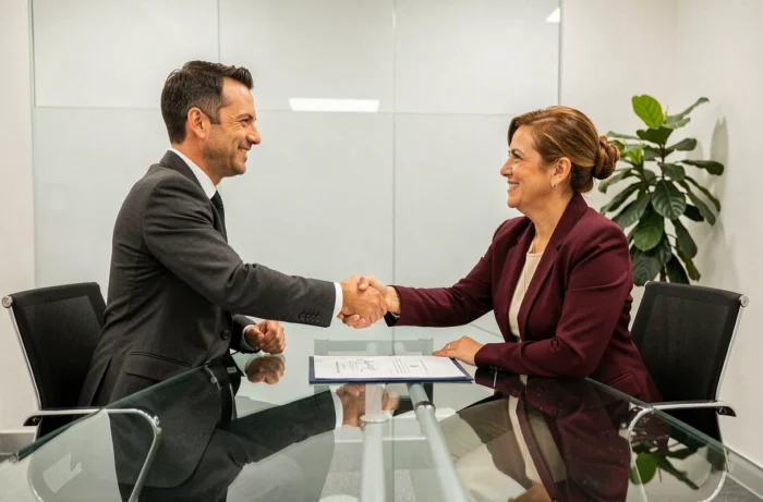 Deux dirigeants d'entreprise signant un contrat juridique dans une salle de réunion moderne